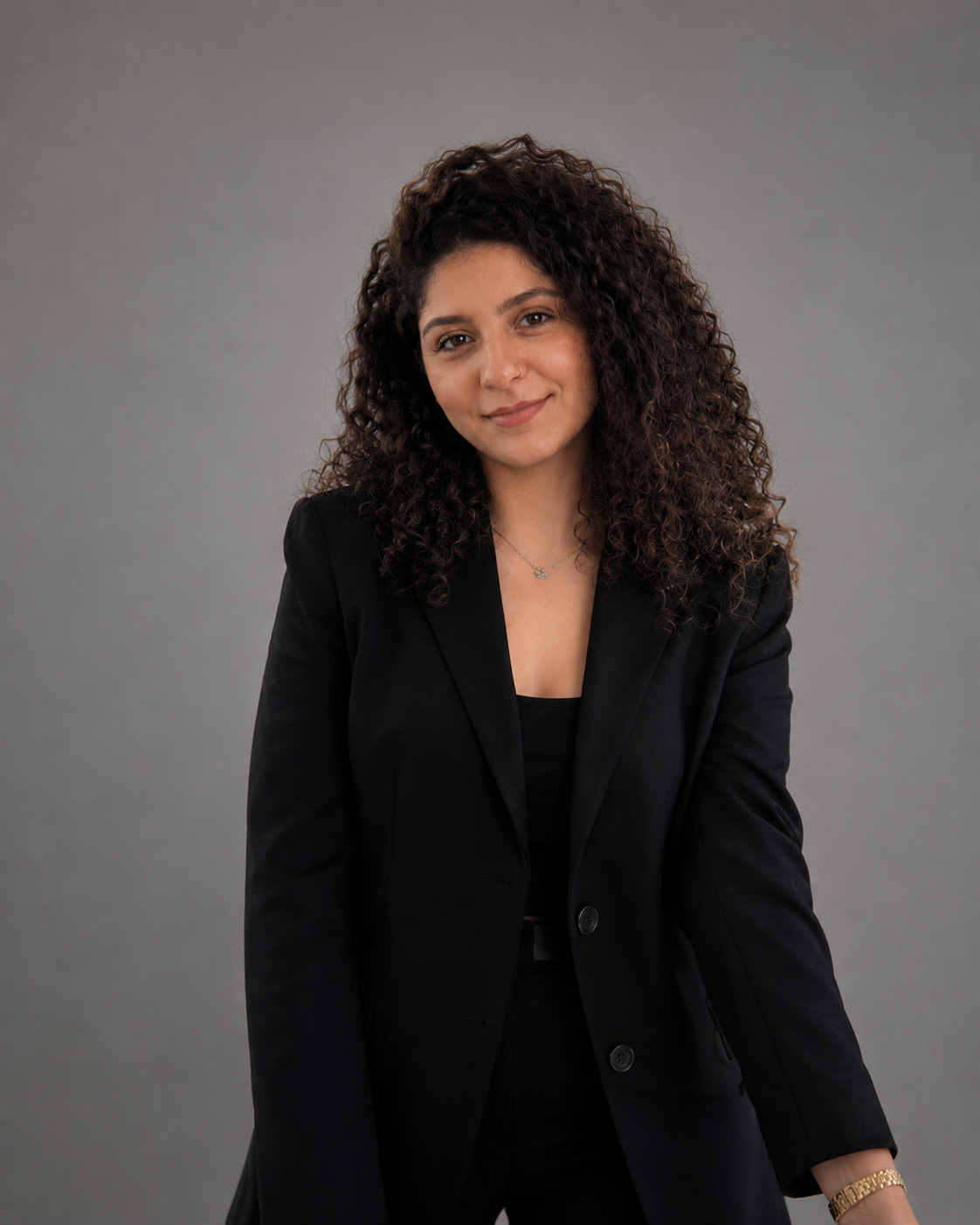 Woman wearing a black blazer against a gray background